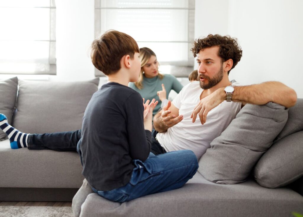 Family on a couch with dad speaking to his son