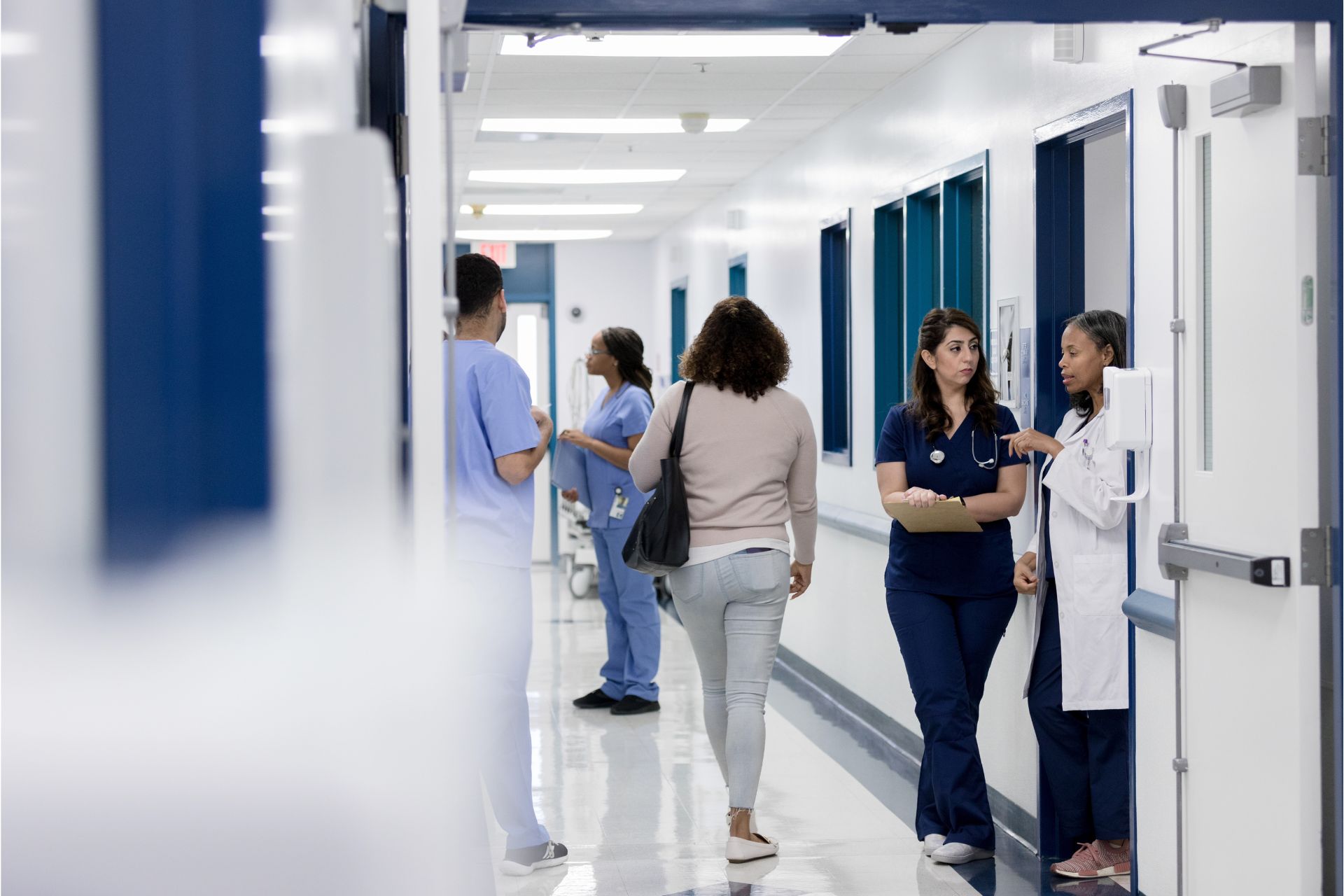 Doctors and nurses conversing in the hallway of a hospital